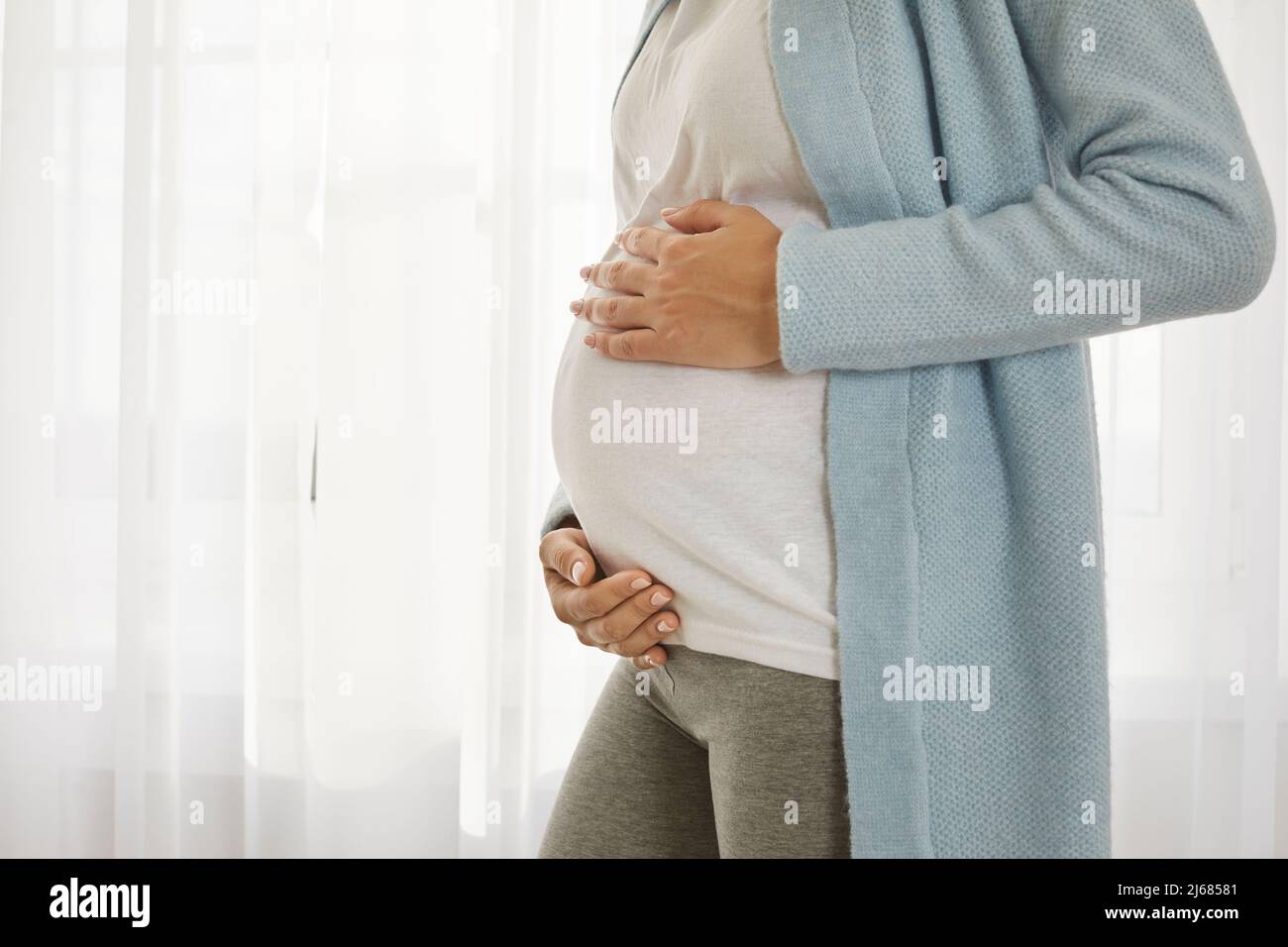 Primer plano de la barriga embarazada de una mujer joven que está en el tercer trimestre del embarazo. Foto de stock