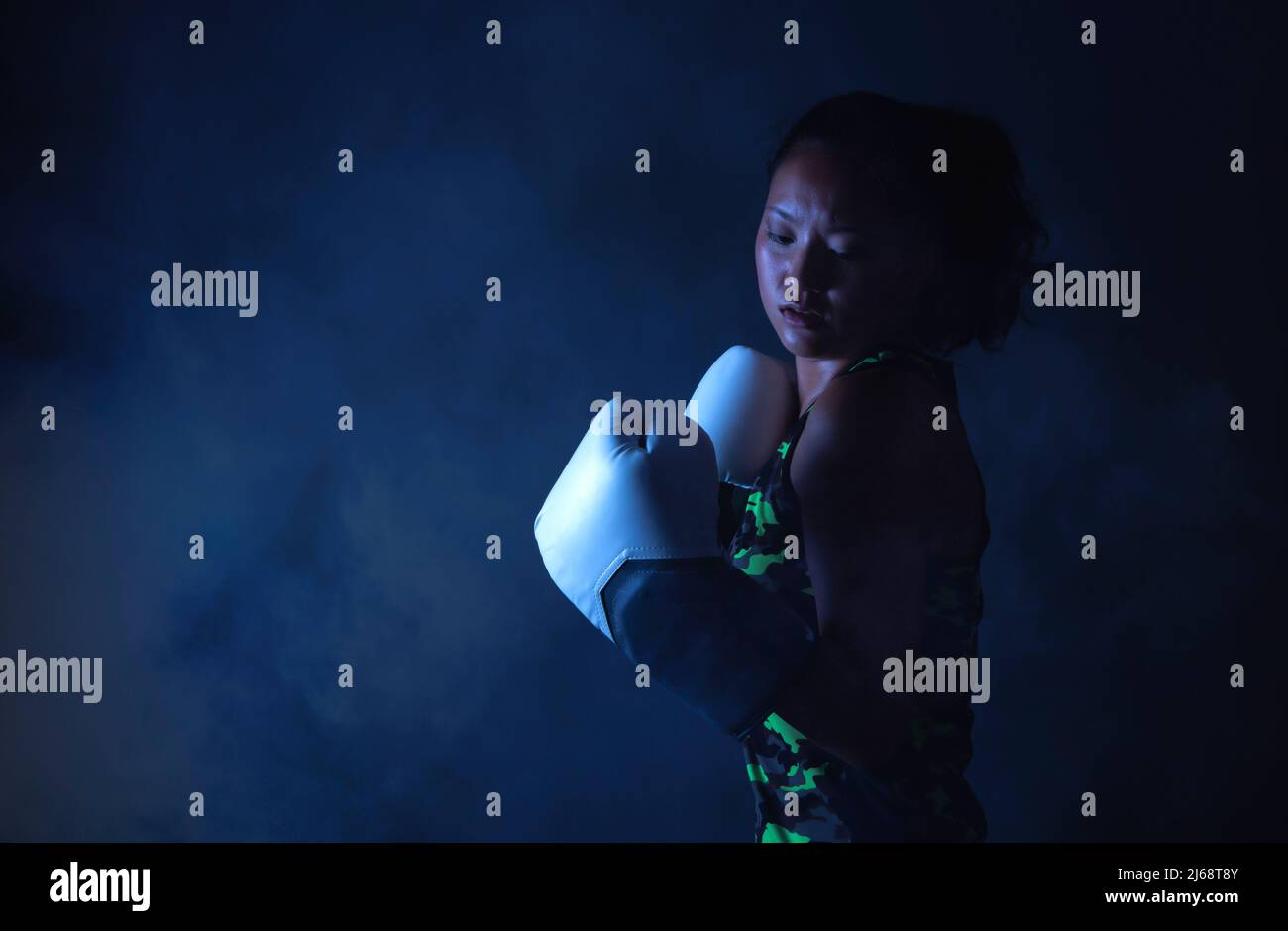 mujer joven de origen asiático con guantes de boxeo Foto de stock