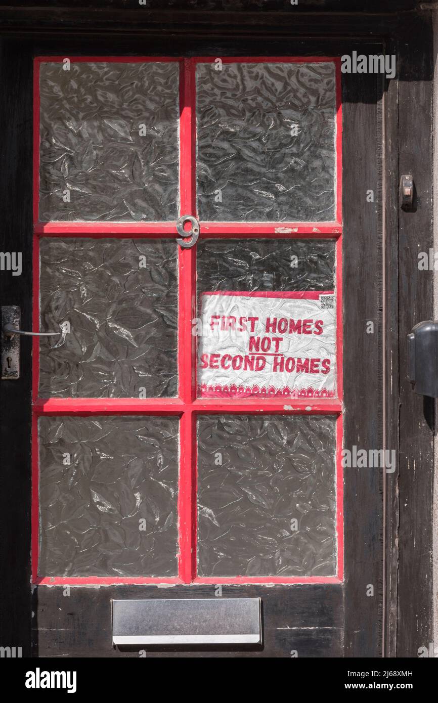 Los primeros hogares no los segundos aviso de los hogares exhibidos en la puerta delantera de una vieja casa en Lostwithiel, Cornualles en referencia a los segundos dueños caseros de Cornualles. Foto de stock