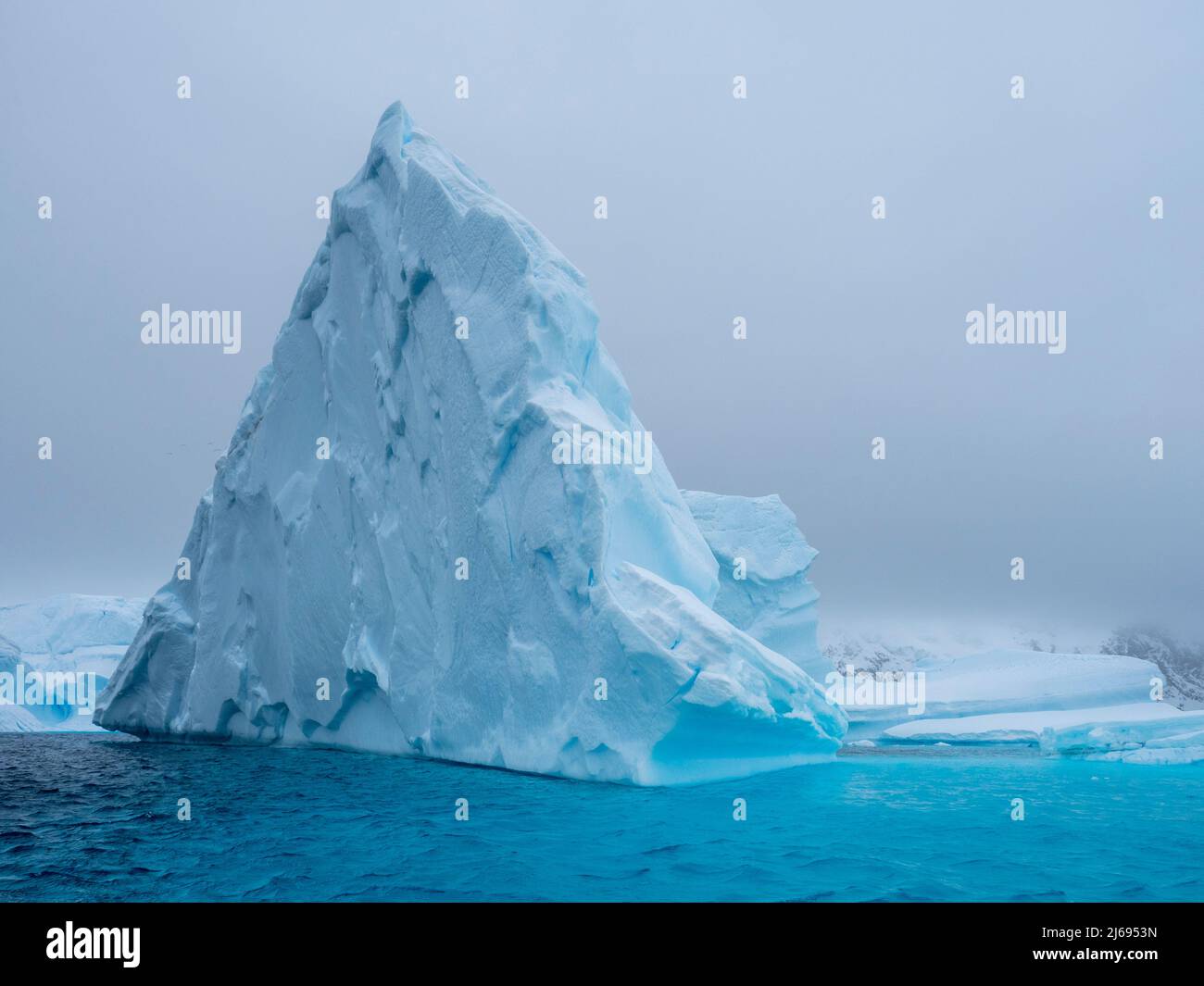 Un enorme iceberg con base en un arrecife cerca del cementerio de Iceberg, la isla Petermann, la Antártida, las regiones polares Foto de stock