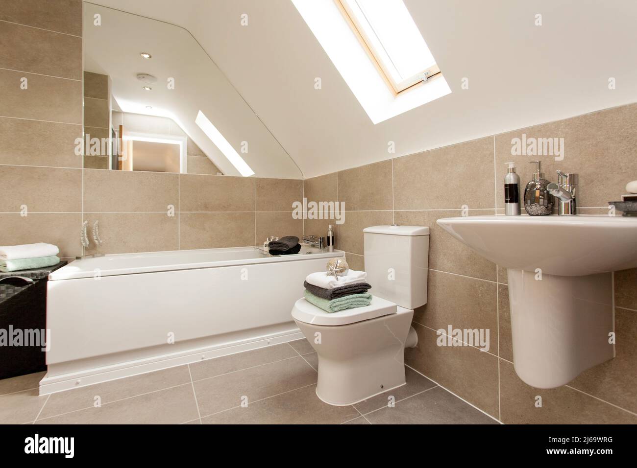 Moderno baño con azulejos en colores neutros. Foto de stock