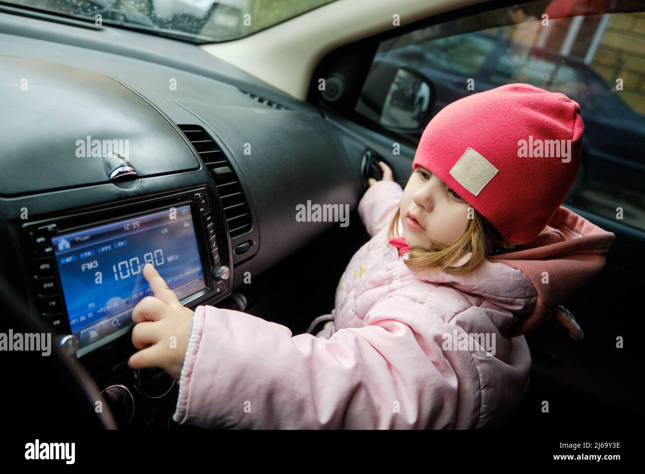 Una niña cambiando de emisora de radio mientras escucha música en coche.  Escuchar la radio en el coche. Música automática Fotografía de stock - Alamy