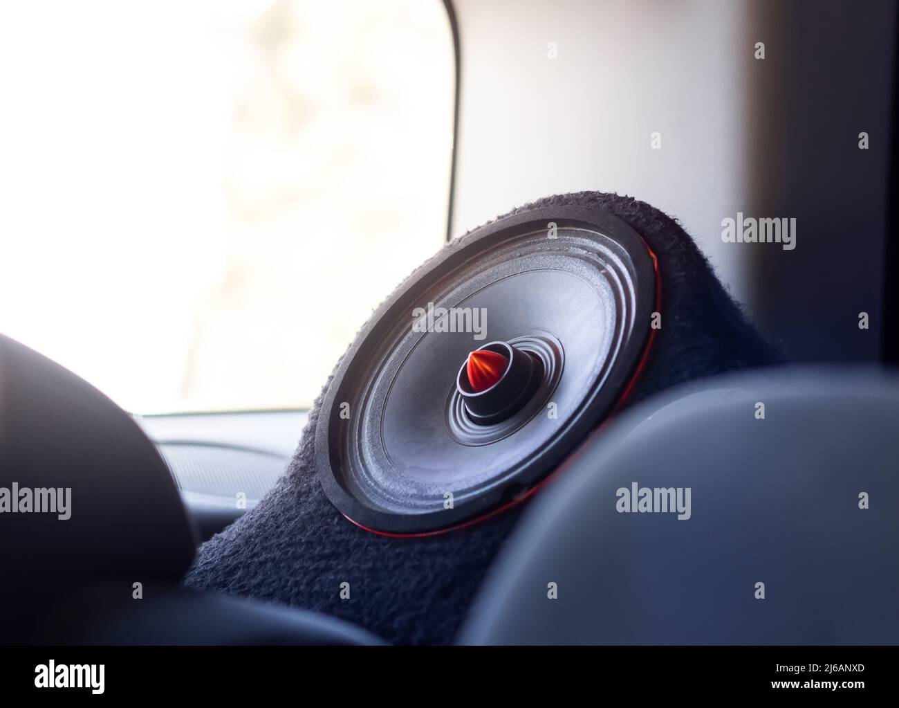 Altavoz para coche. Moderno altavoz con sonido para coche con detalles en rojo. Luz solar Foto de stock