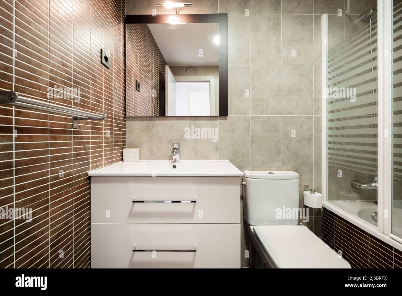 Baño con cabina de ducha espejo empotrado en pared cenefas de porcelanato y  lavabo sobre mueble de madera