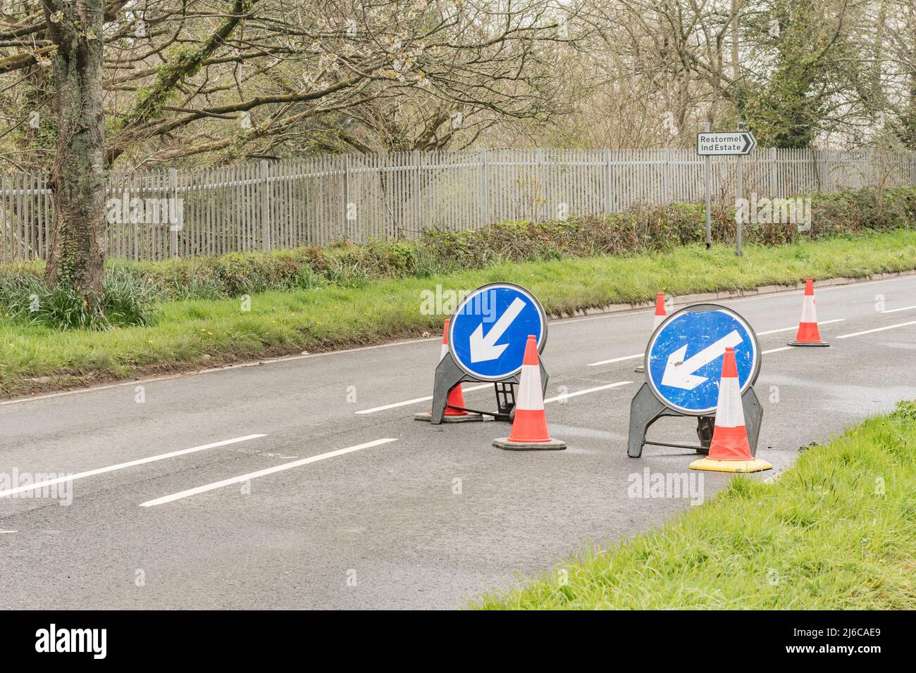 Siga las señales azules de la izquierda en el Reino Unido, como parte de la señalización de obras en una carretera de Cornwall. Para reparaciones o mantenimiento de carreteras, el tráfico se ralenti. Foto de stock