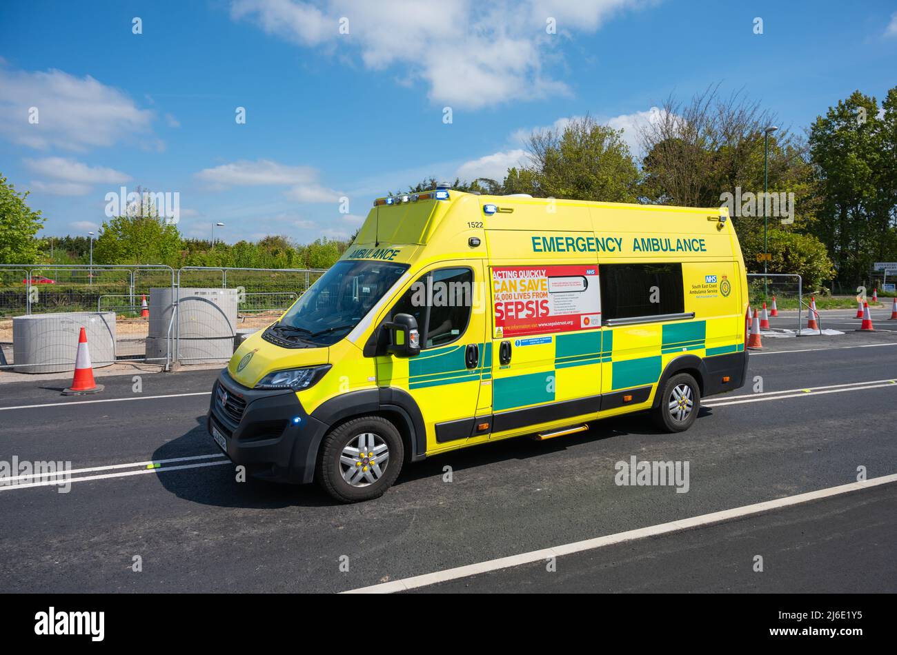 Ambulancia de emergencia del NHS en una llamada con luces azules parpadeantes en una carretera principal en West Sussex, Inglaterra, Reino Unido. El vehículo es un Fiat Ducato. Foto de stock