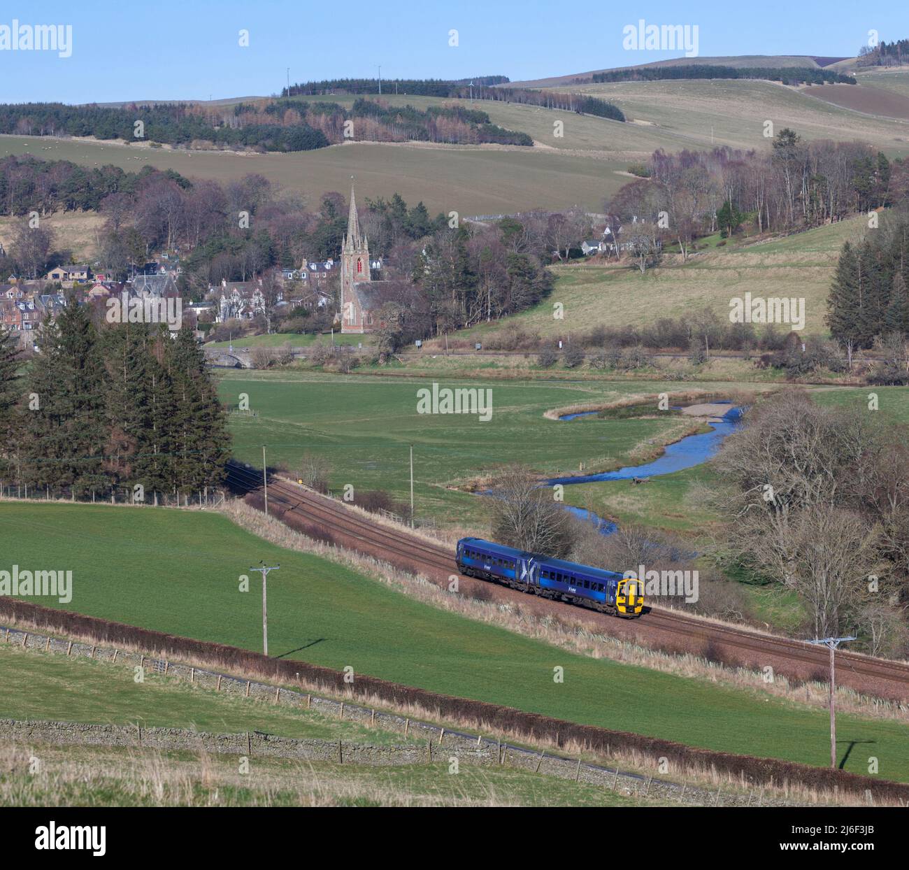 ScotRail clase 156 DMU tren 158728 pasando por el campo y Stow St Mary de Wedale y la iglesia Heriot en la frontera de ferrocarril, Escocia Reino Unido Foto de stock