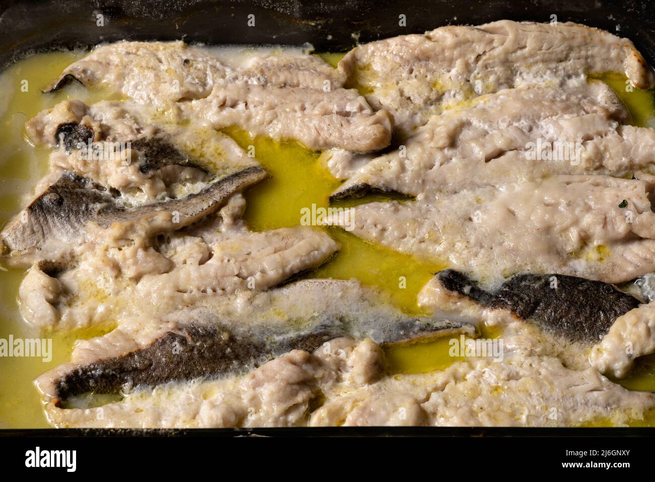 Filetes de pescado blanco asados en el horno con especias en una bandeja de cristal. Concepto de cocina casera. Foto de stock