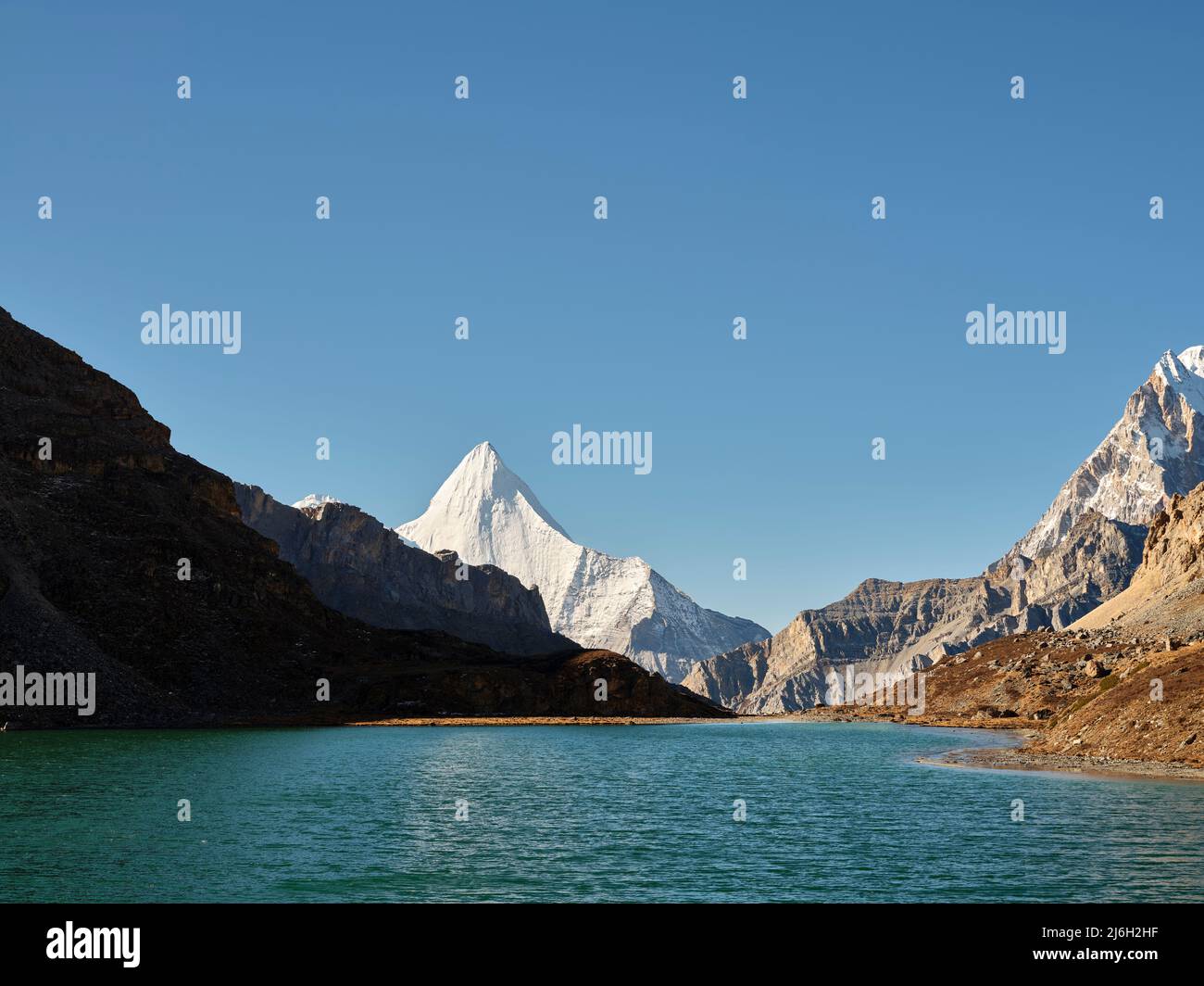 monte yangmaiyong (o jampayang en lengua tibetana) y lago boyongcuo bajo el cielo azul en yading, condado de daocheng, provincia de sichuan, china Foto de stock