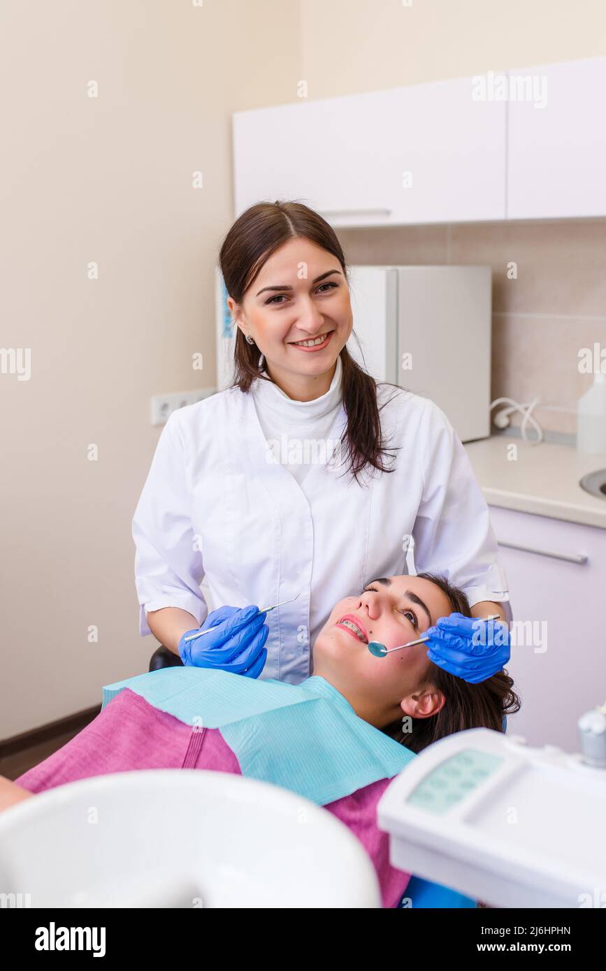 La mujer dentista trata a un paciente. Una mujer en una máscara se sienta  en una silla dental en la clínica. Medicina, salud, concepto de odontología  Fotografía de stock - Alamy