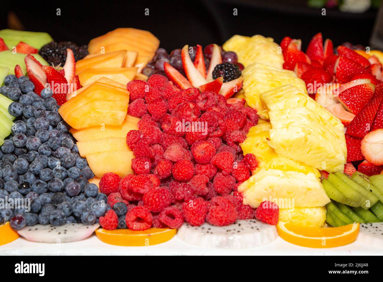 Fruta colorida, cortada en rodajas y servida en un almuerzo buffet Foto de stock