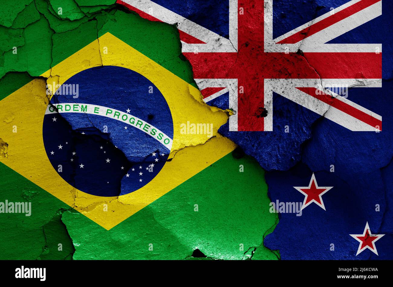 Banderas de Brasil y Nueva Zelanda pintadas en la pared agrietada Foto de stock