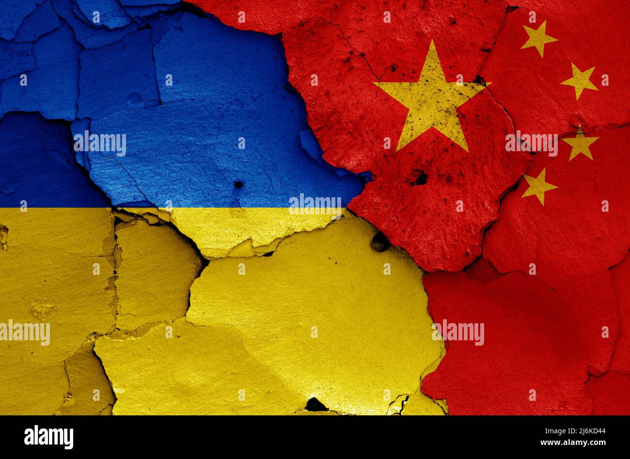 Banderas de Ucrania y China pintadas en una pared agrietada Foto de stock