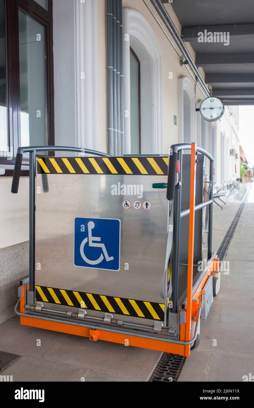 Ascensor especial para sillas de ruedas en la estación de tren. Servicio de asistencia para pasajeros con discapacidad ferroviaria. Foto de stock