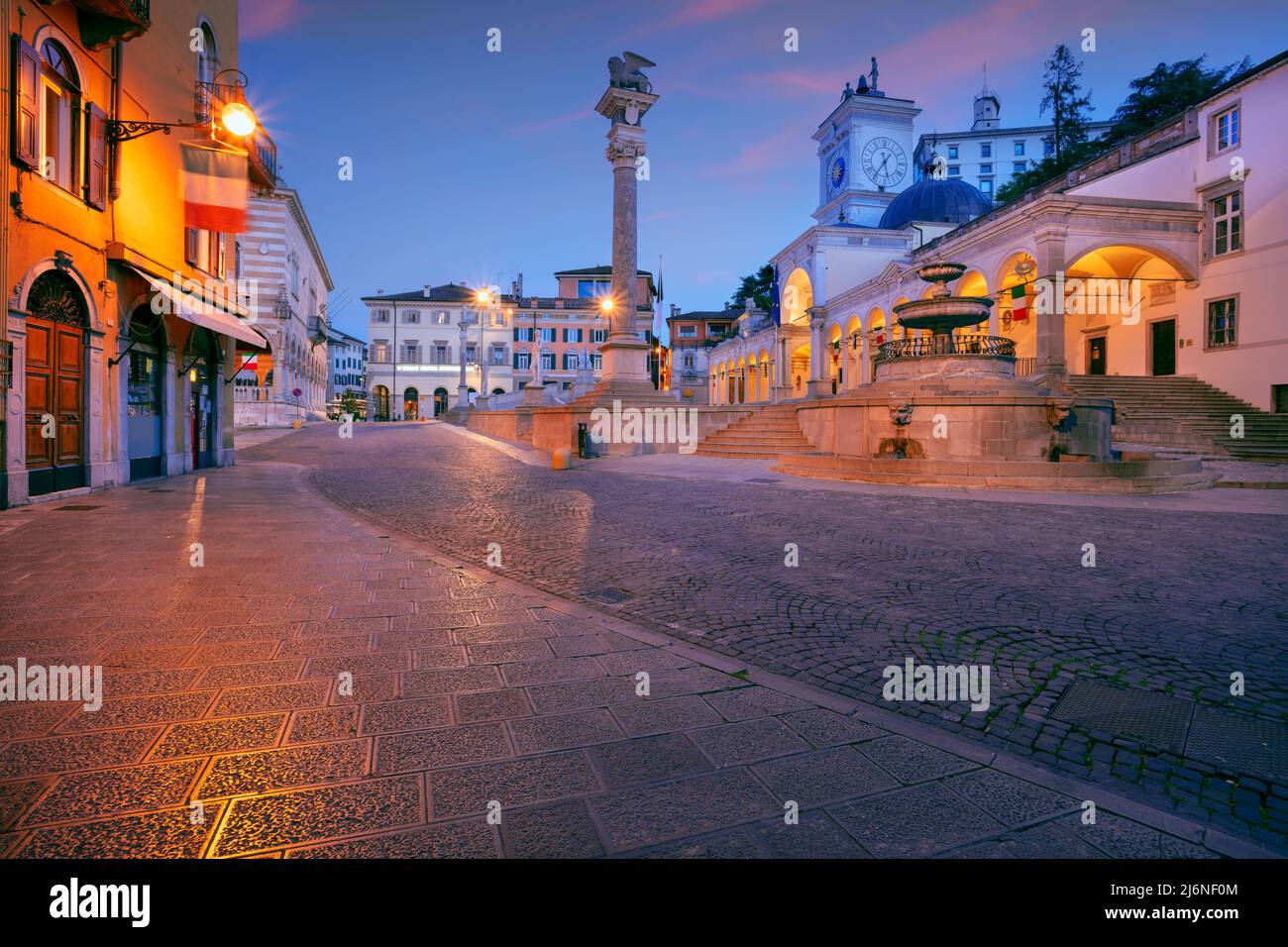 Udine, Italia. Imagen del paisaje urbano del centro de Udine, Italia, con la plaza de la ciudad al amanecer. Foto de stock