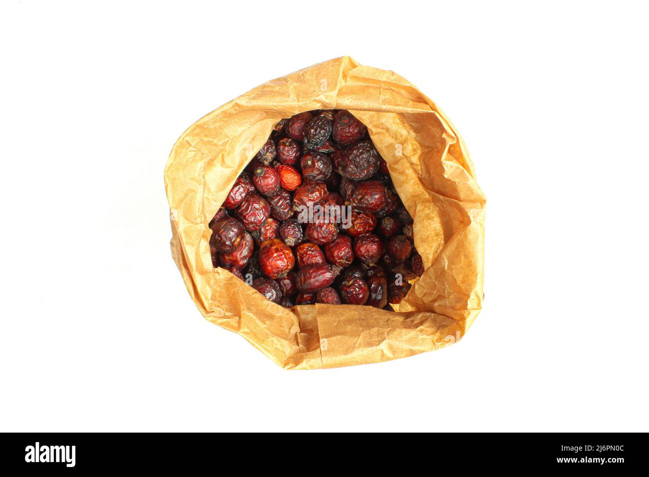 Bolsa de papel llena de caderas secas de arriba y aisladas sobre fondo blanco Foto de stock