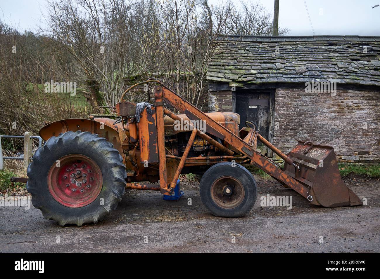 Tractor principal Fordson viejo y oxidado con accesorio de digger. Foto de stock