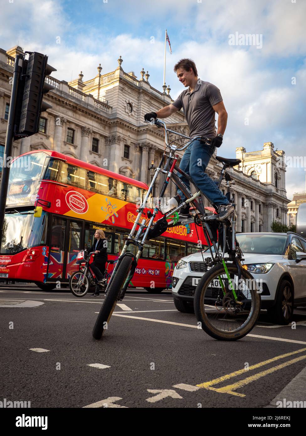 Un hombre montando una bicicleta muy alta en el tráfico de la ciudad de  Londres Fotografía de stock - Alamy