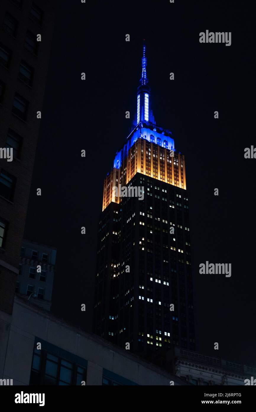 Edificio Empire State en la ciudad de Nueva York iluminado en azul y amarillo para apoyar a Ucrania Foto de stock