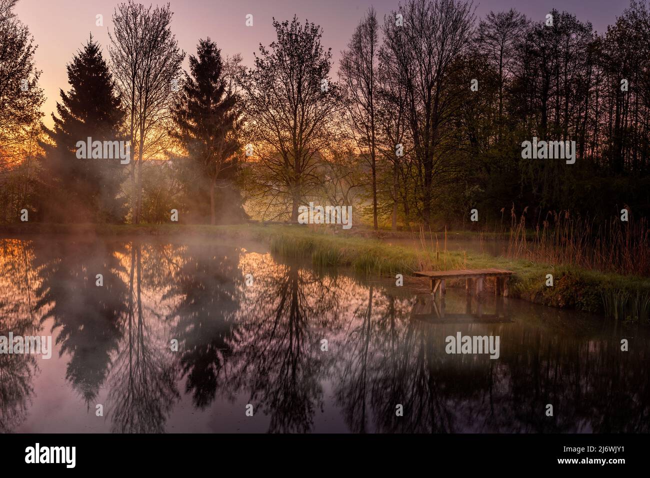 Amanecer sobre un estanque en Baviera con niebla creciente Foto de stock