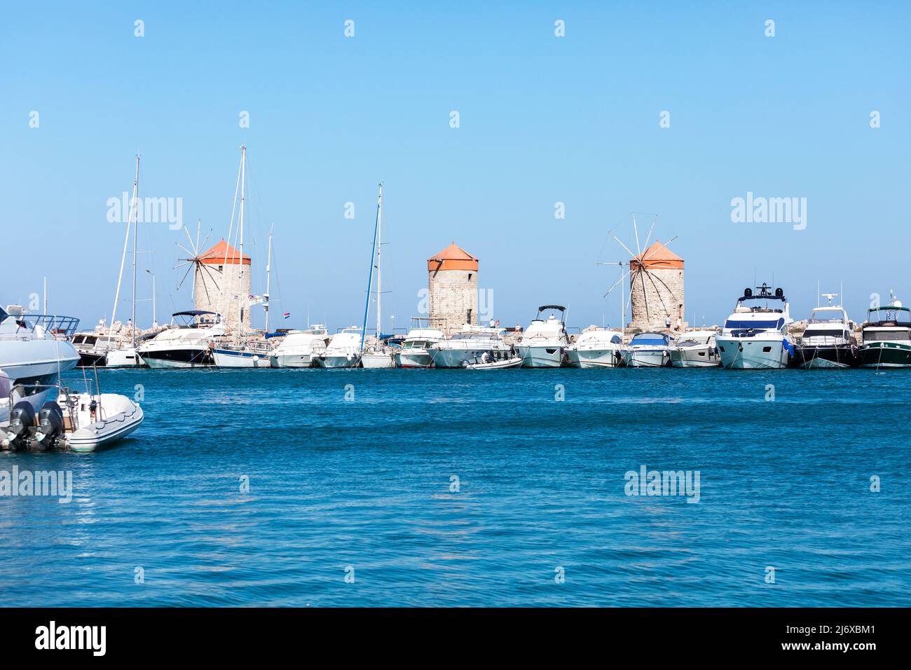 Molinos de viento en el puerto de Mandraki Rodas, Grecia Foto de stock