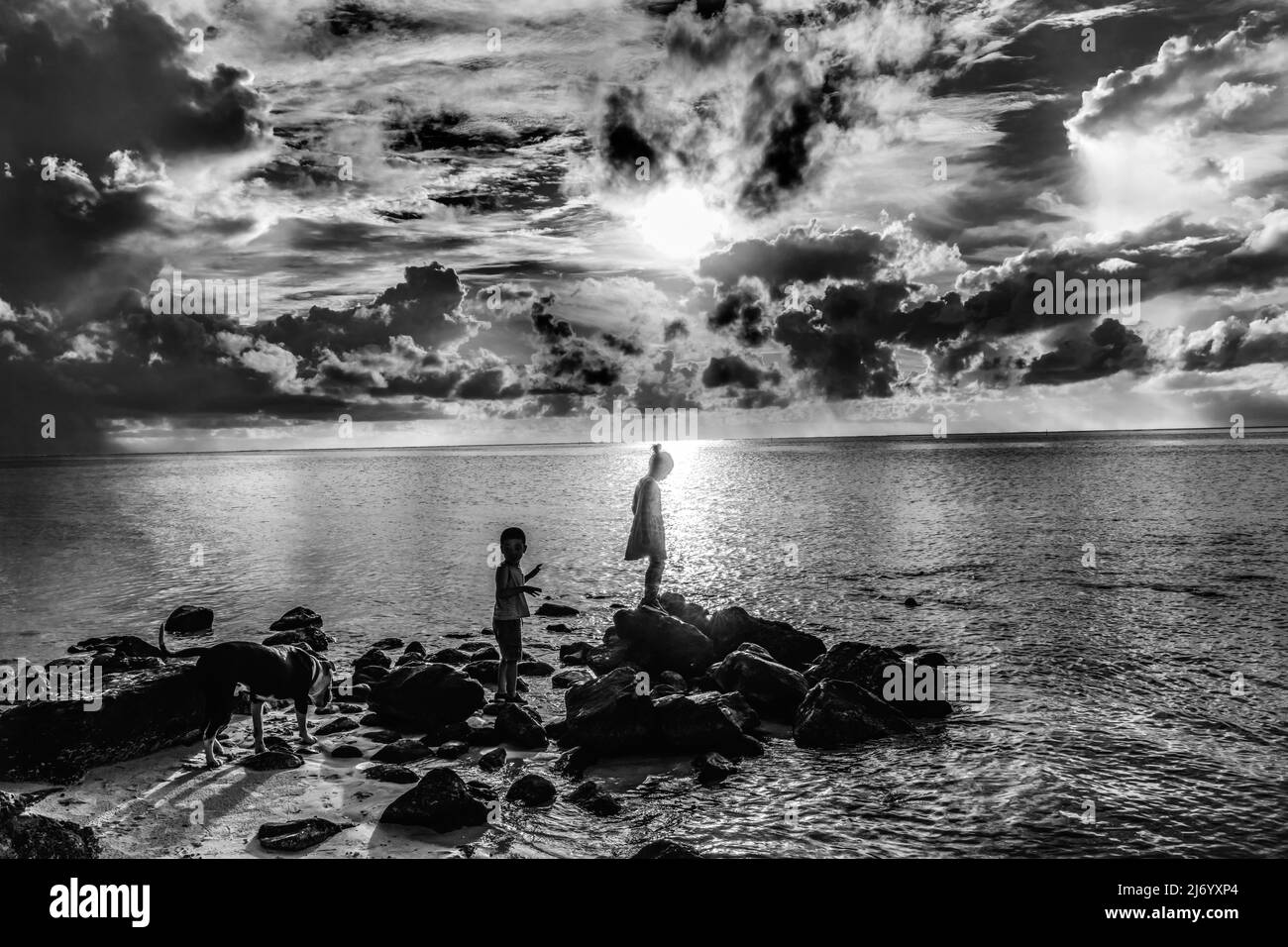Niño joven Reflexión al atardecer Cloudscape Agua Moorea Tahití Polinesia Francesa. Foto de stock