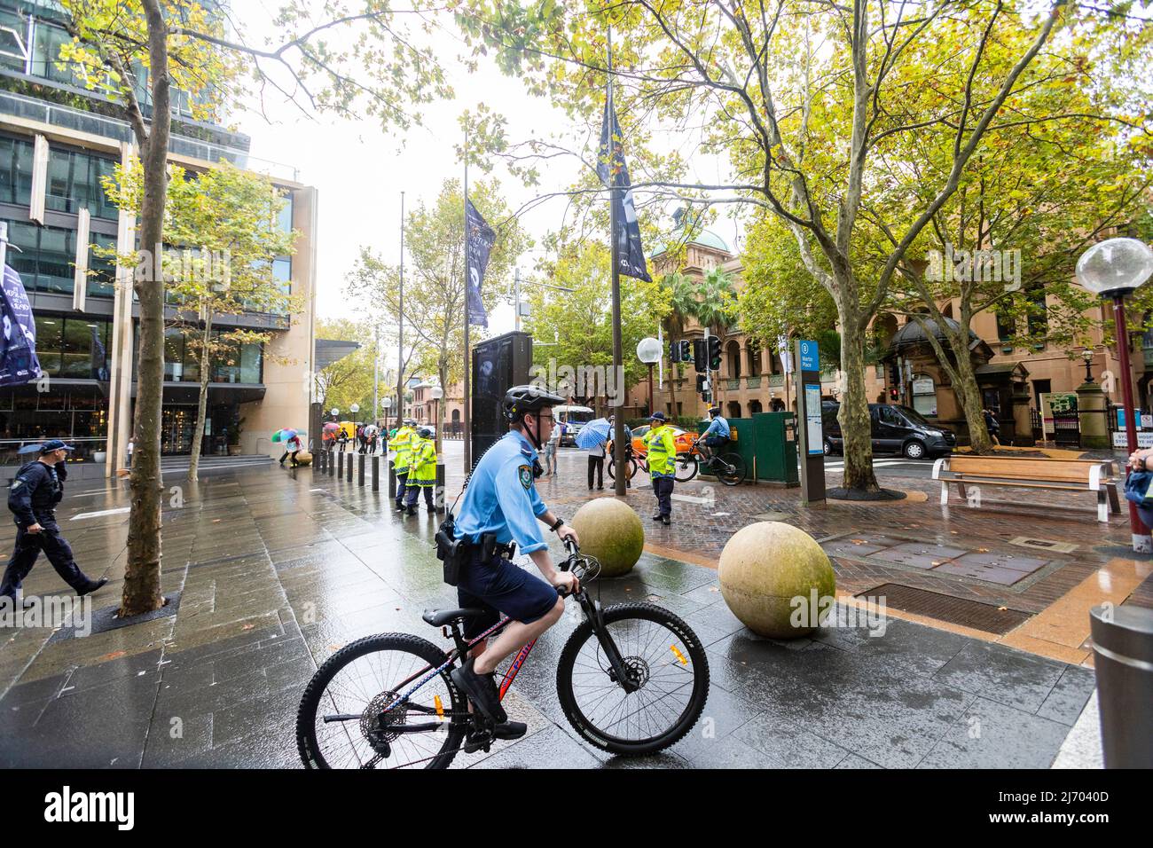 Policía masculina australiana con uniforme y pantalones cortos montando en bicicleta en el centro de la ciudad de Sydney, Nueva Gales del Sur, Australia Foto de stock