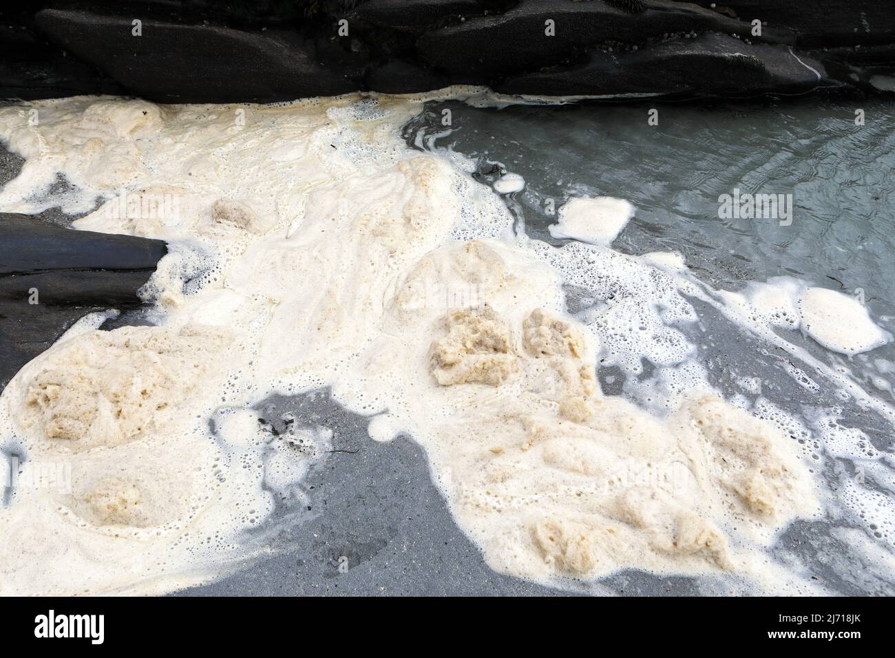 Espuma de surf también conocida como scum de surf en una playa escocesa Foto de stock