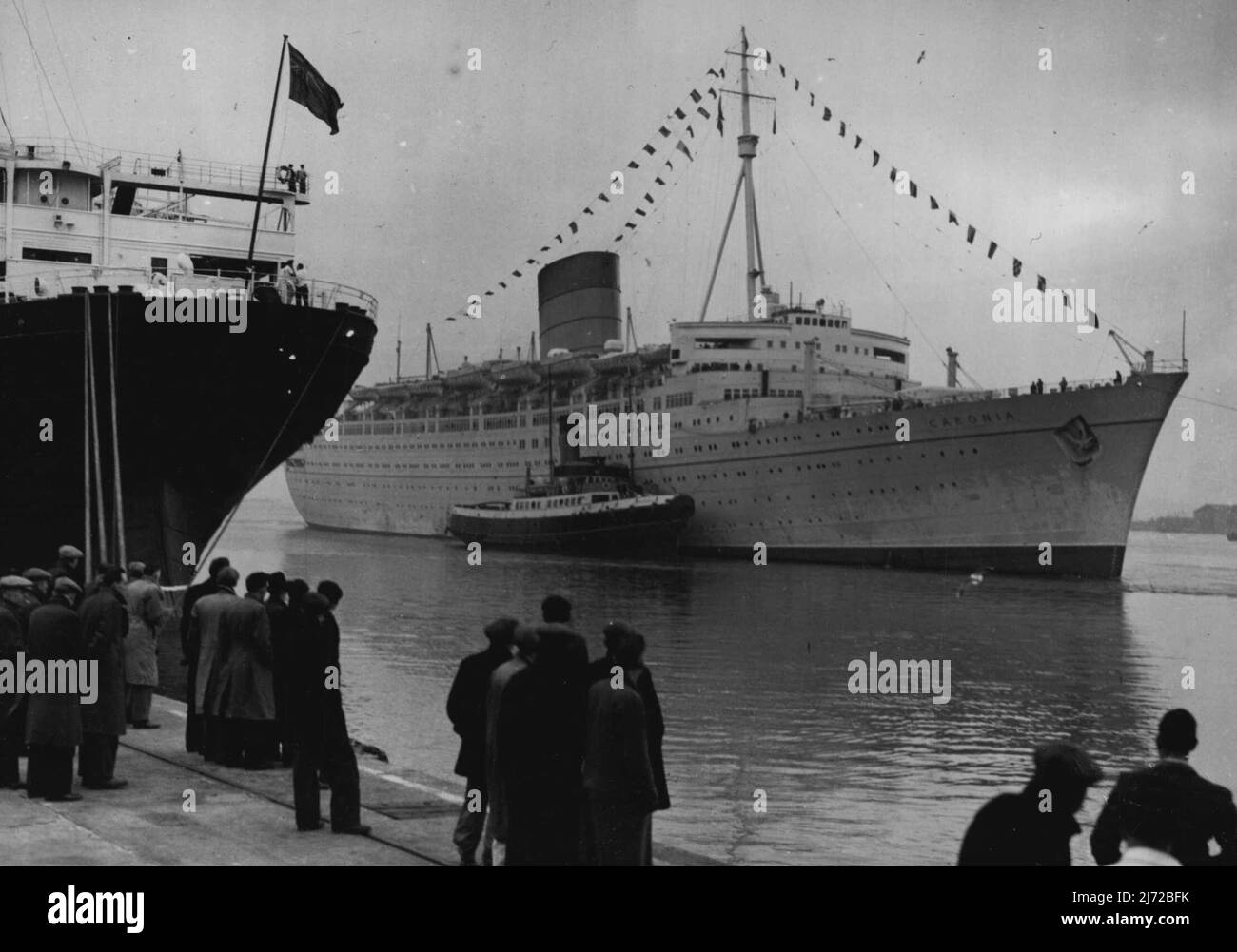 La línea de postguerra más grande del mundo en Southampton -- la 'Caronia', la línea más grande construida en el mundo desde el final de la guerra, pasa por la antigua 'Aquitania' cuando llega aquí después de su crucero de fin de semana desde Gourock, Escocia. Entre sus pasajeros estaba el Duque de Edimburgo. El transatlántico de 34.000 toneladas, fue lanzado en los astilleros John Brown en Glasgow por la Princesa Elizabeth en 1947. 20 de diciembre de 1948. Foto de stock