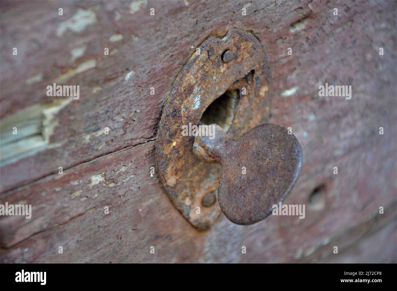 Una vieja cerradura rosada en un agujero marrón de madera door.Rusty door.Key. Foto de stock