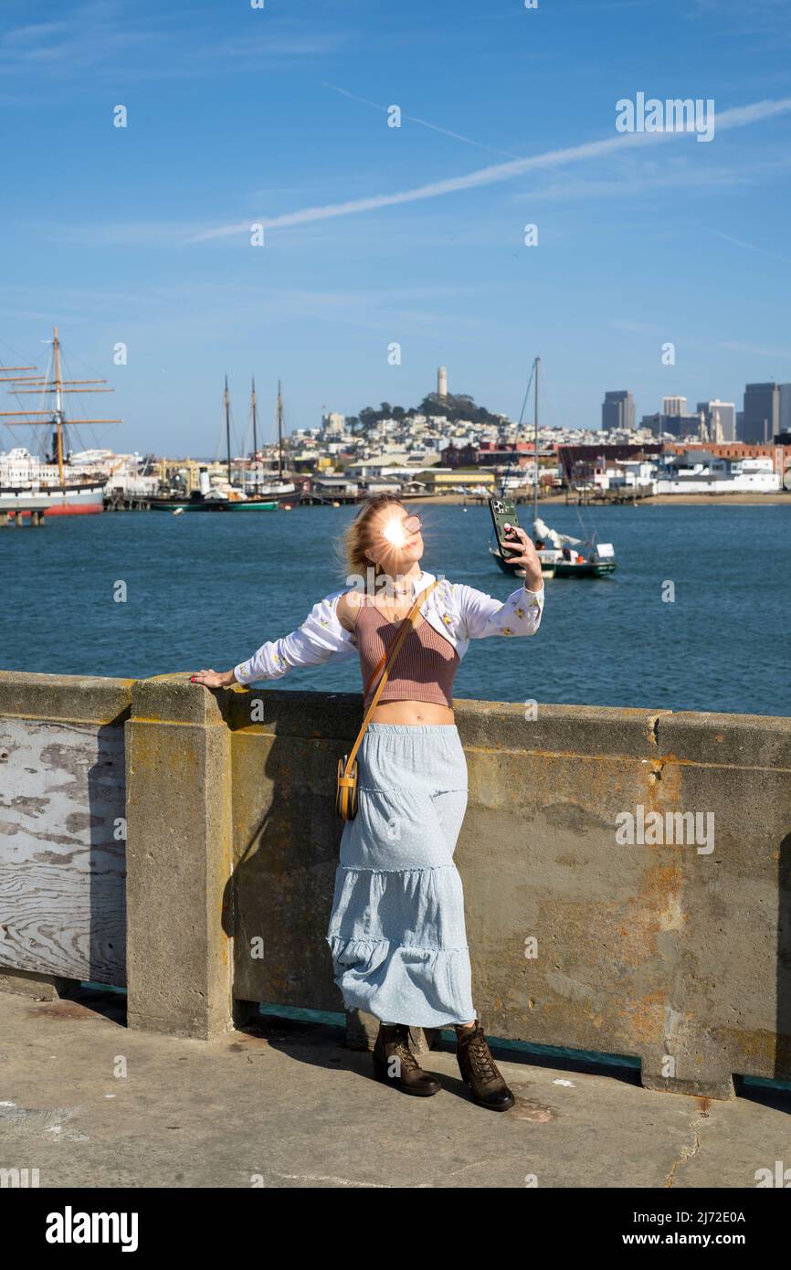 Mujer joven visitando el muelle del parque acuático en San Francisco | Turismo de estilo de vida Foto de stock