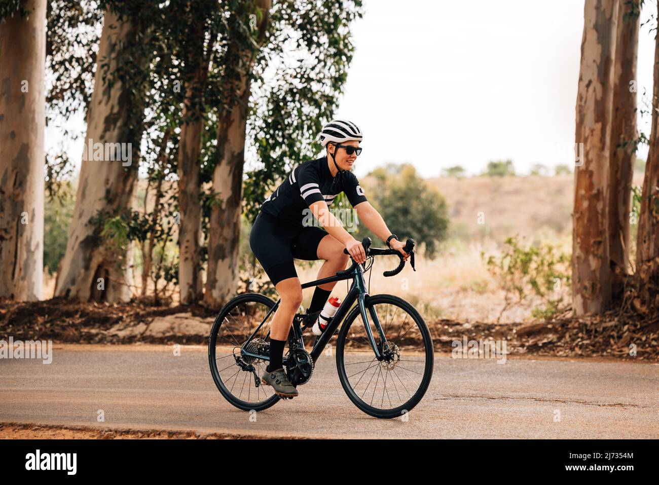 Profesional ciclista mujer en gafas de sol y casco montar en bicicleta al aire libre Fotografía stock - Alamy