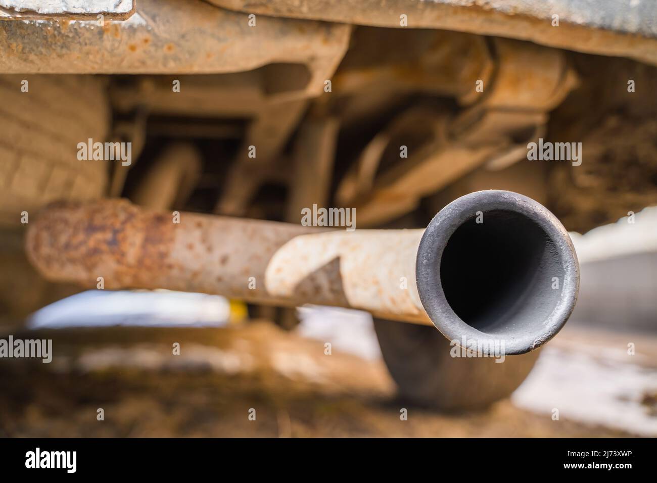 Tubo de escape de un coche de cerca en tiempo soleado. Fondo oxidado.  Emisiones de aire Fotografía de stock - Alamy