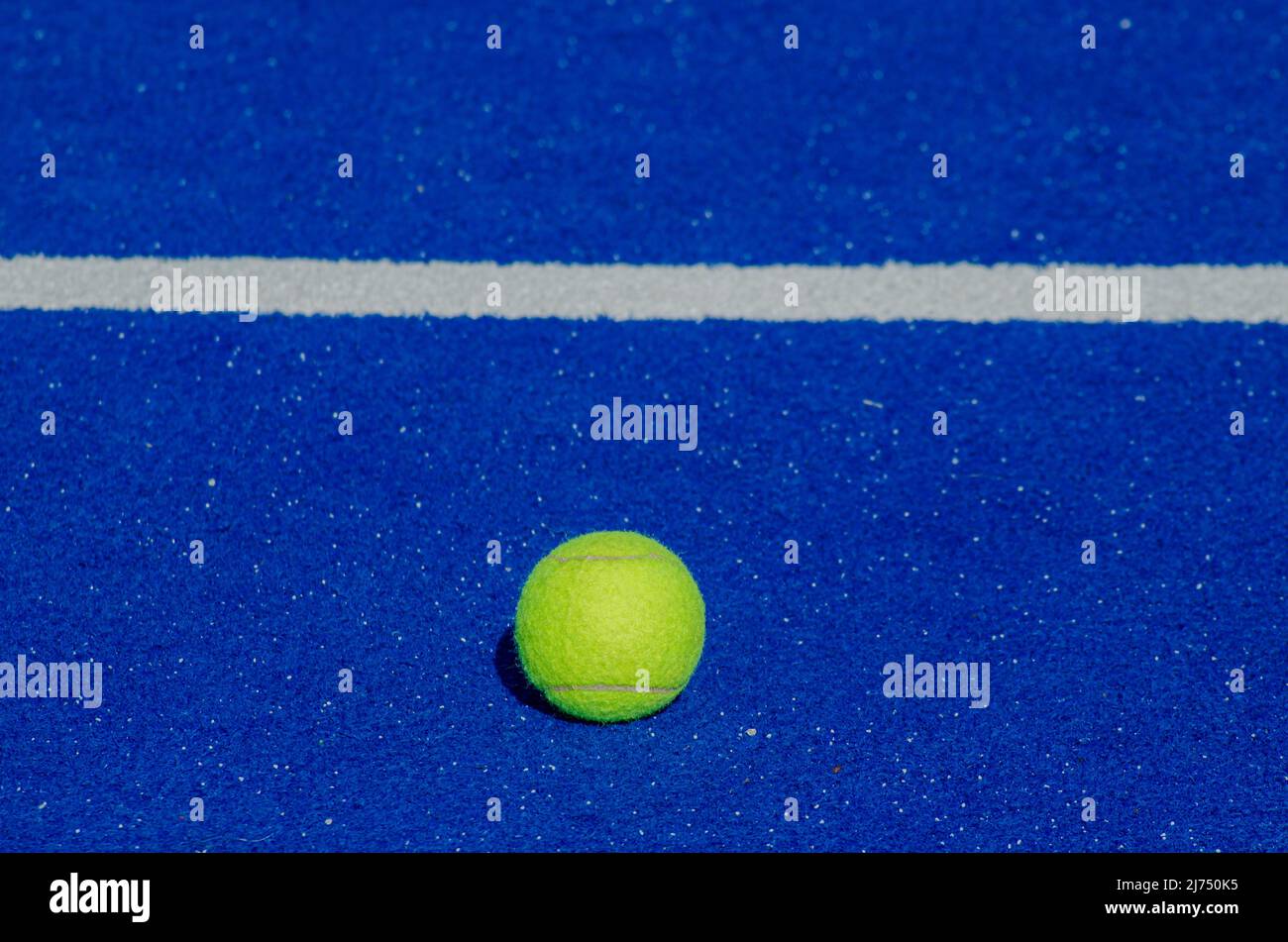 pista de tenis blue paddle, una sola pelota cerca de la línea de base Foto de stock