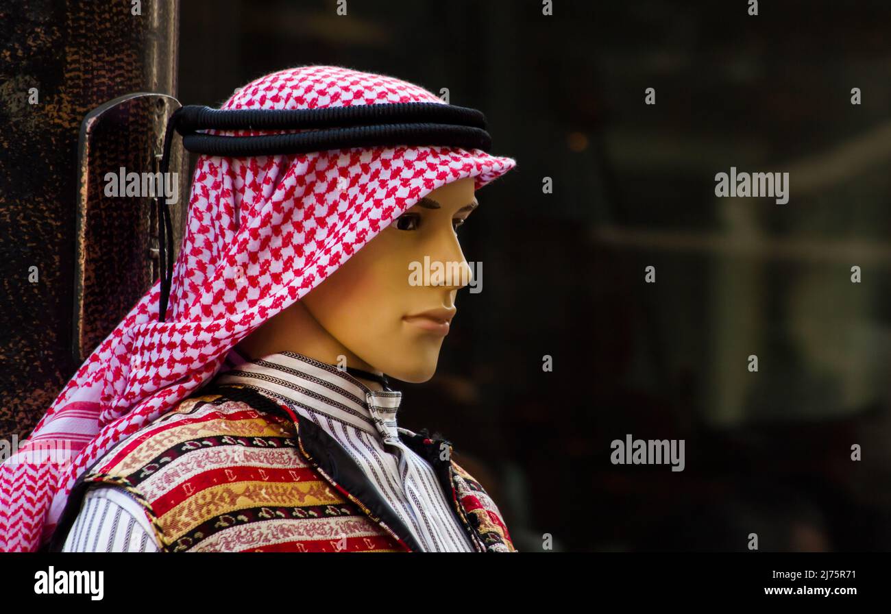 Maniquí macho con ropa árabe local y tradicional sobre fondo negro y borroso Foto de stock