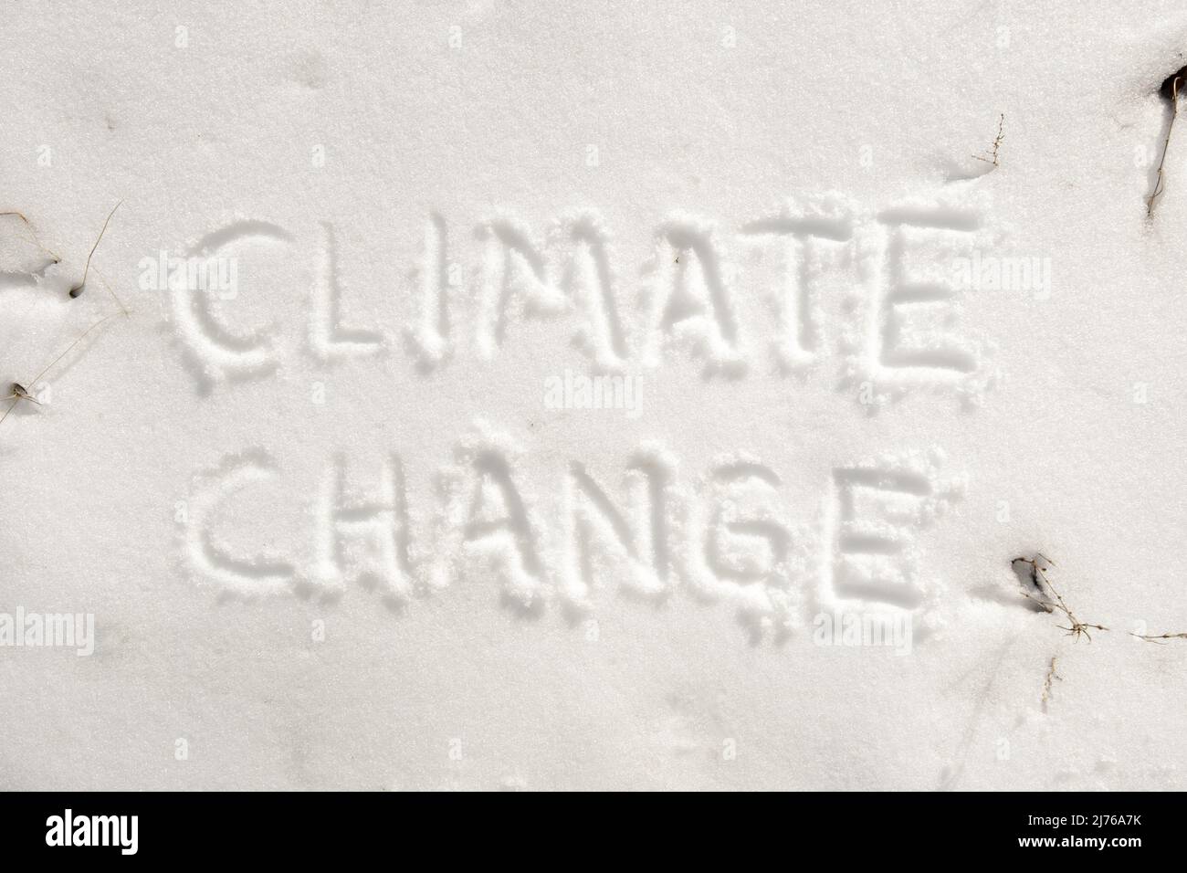 Texto 'cambio climático' escrito sobre terreno nevado Foto de stock