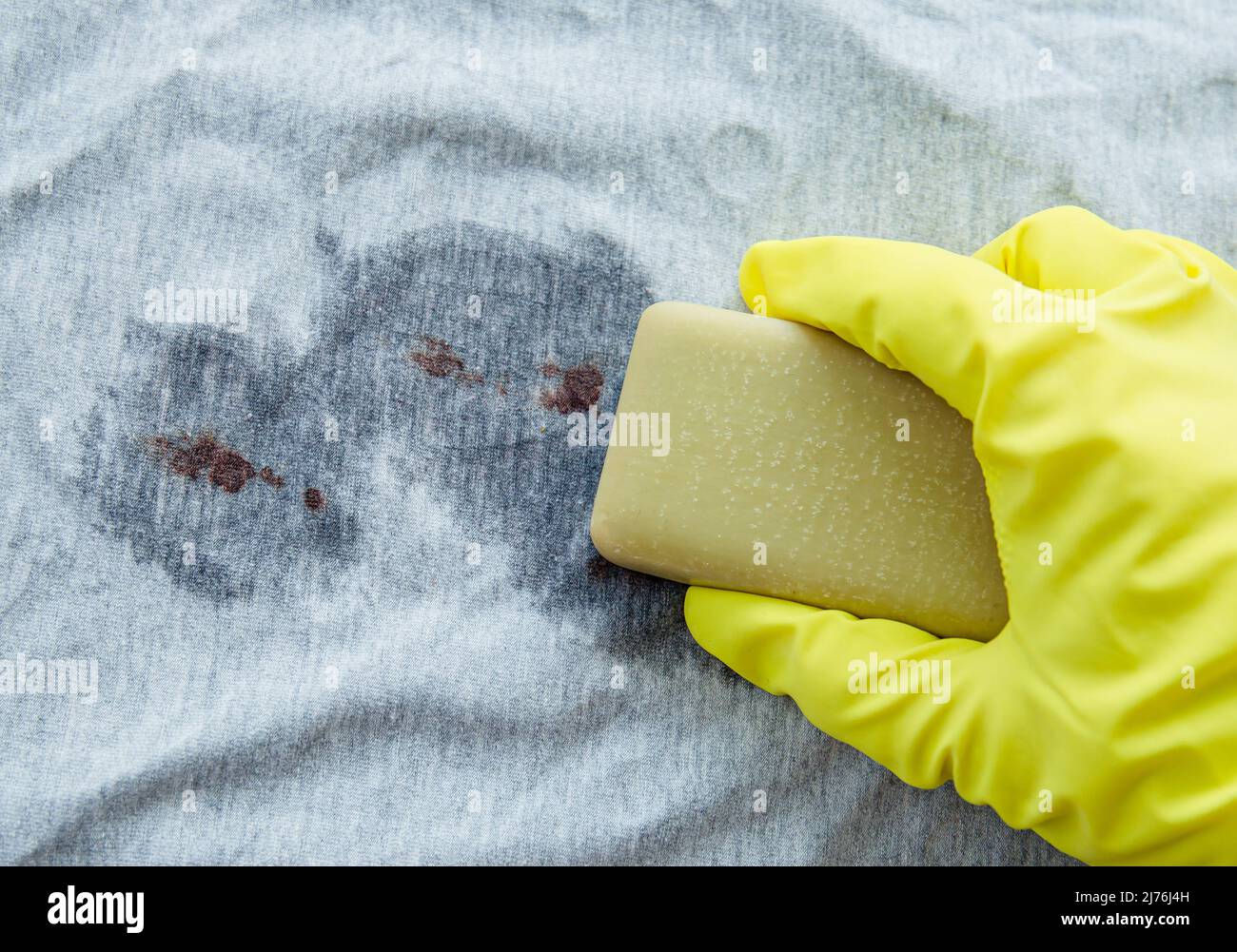 Eliminar las manchas de sangre con una barra de jabón de bilis ( gall, sap). Concepto de productos naturales de lavado de ropa para el hogar sin productos químicos. Jabón de mano. Foto de stock