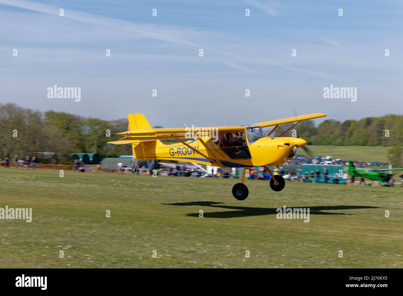 El avión ligero G-RODW AeroPro EUROFOX amarillo brillante llega al aeródromo de Popham, en Hampshire, Inglaterra, para asistir a la reunión anual de aviones ultraligeros Foto de stock
