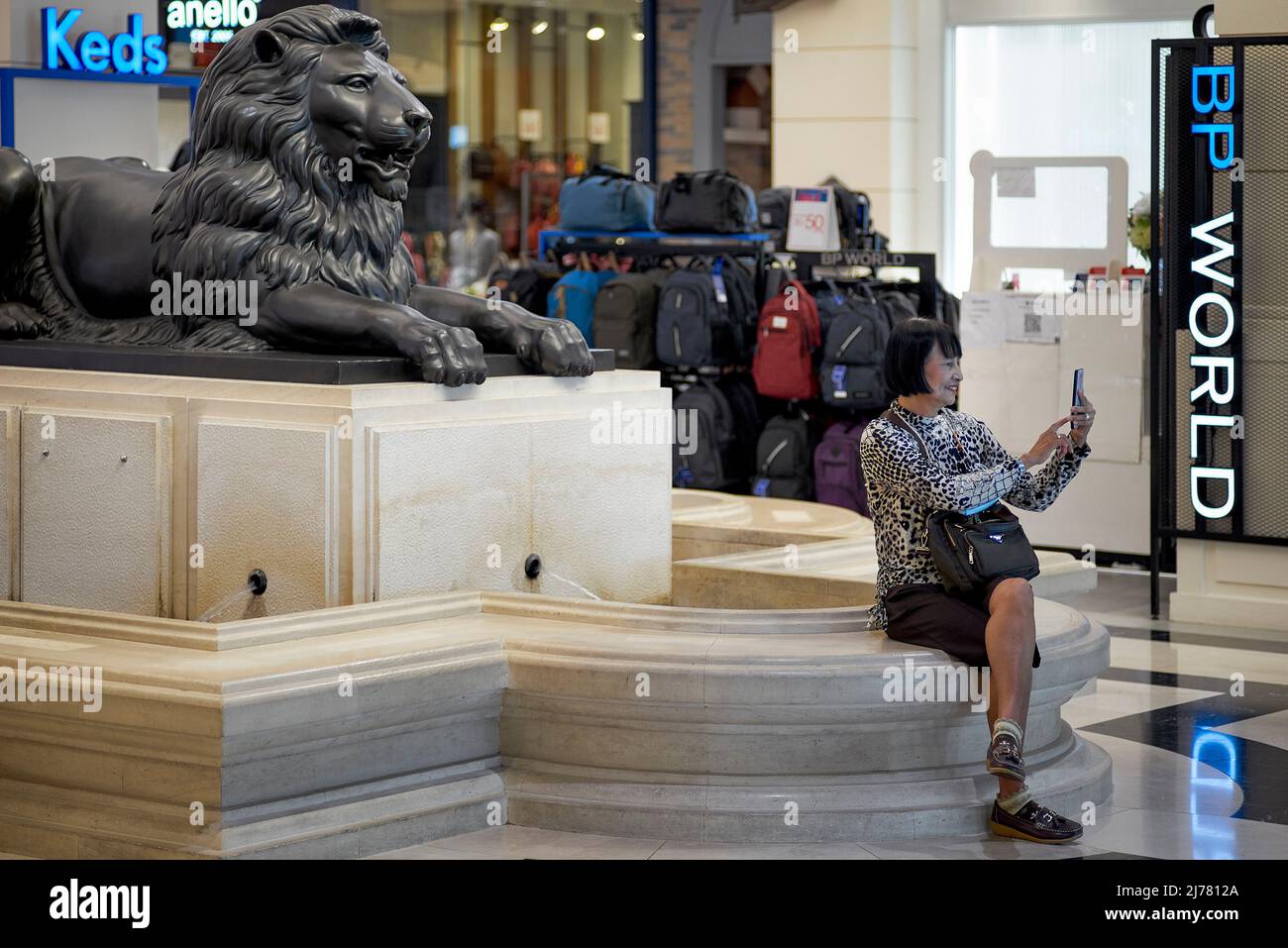 Selfie. Mujer madura tomando fotografías selfie contra un fondo de estatua de león Foto de stock