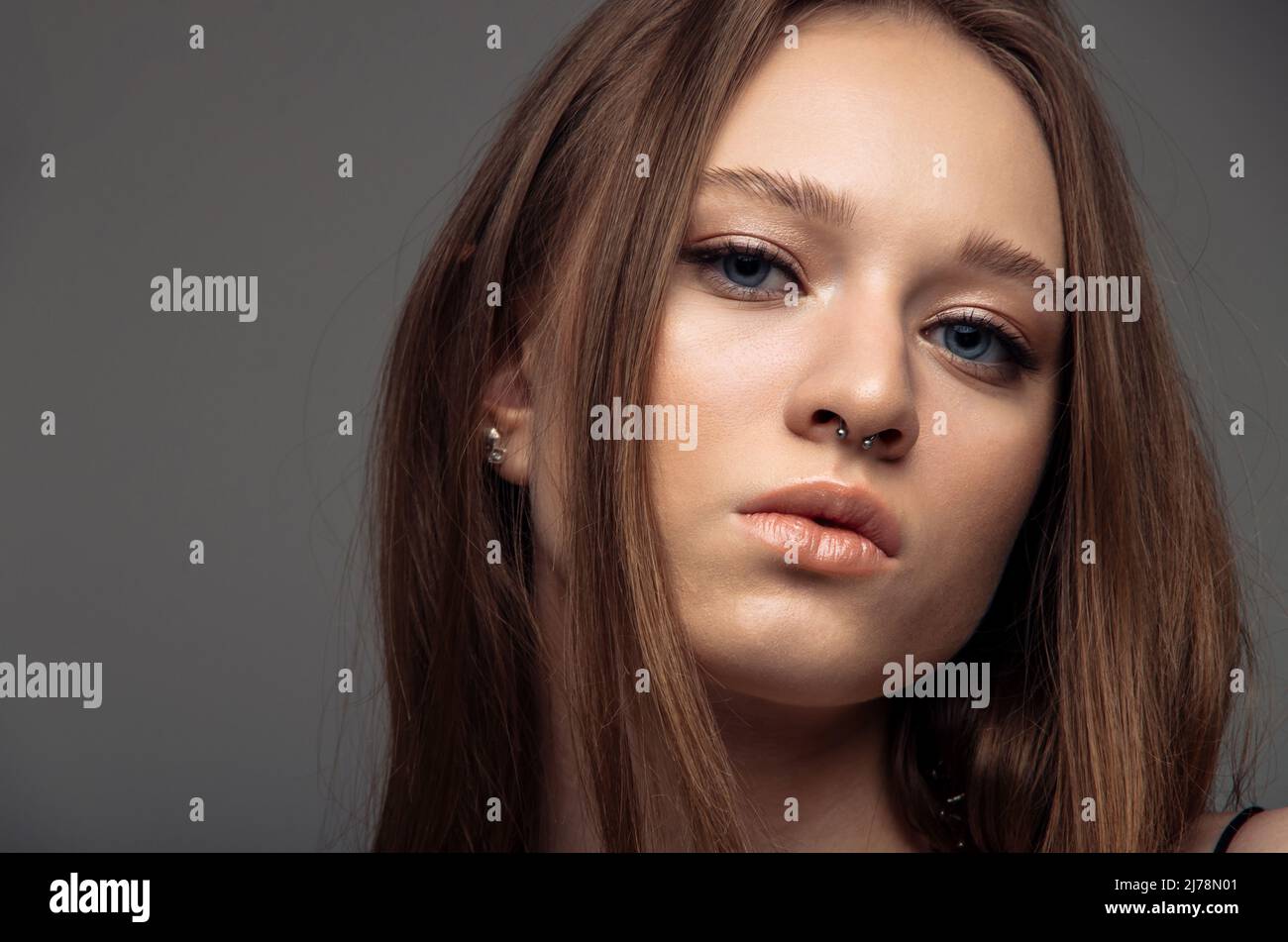Retrato Hermoso modelo posando en estudio sobre fondo gris. Retrato de mujer caucásica. Foto de stock