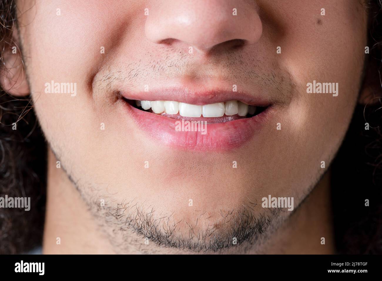 Foto de cerca de una cara sonriente y boca de un hombre joven, de buen aspecto y barbudo. Fotografías de alta calidad Foto de stock