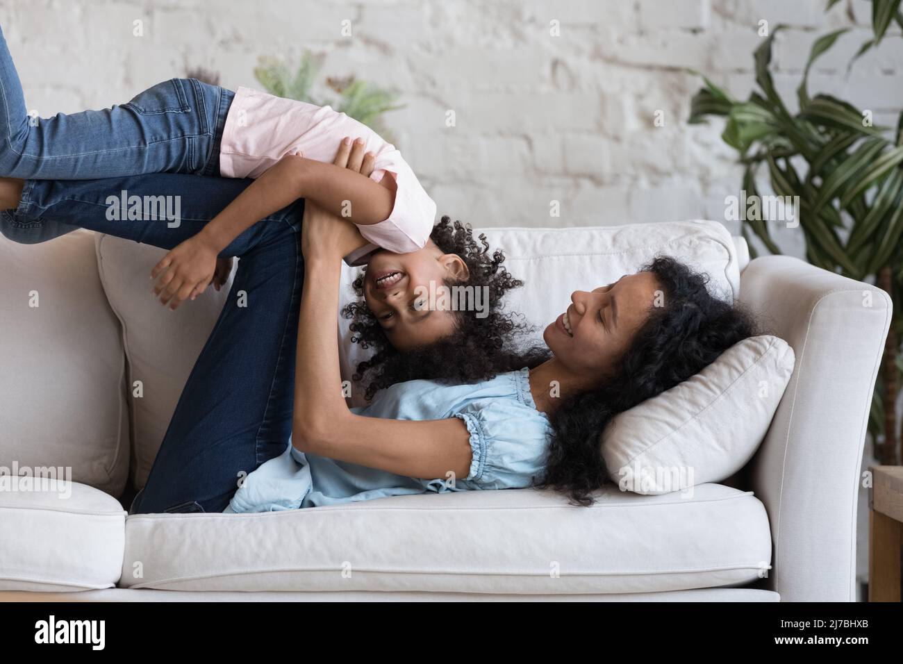 Alegre Negro mamá y niño hija jugando juegos activos Foto de stock