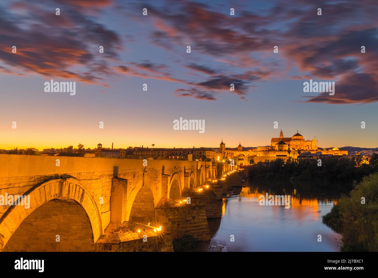 Una noche en el antiguo Puente Romano de Córdoba. Al fondo la Gran Mezquita de Córdoba. Tomada en la ciudad de Córdoba, Andalucía, en t Foto de stock