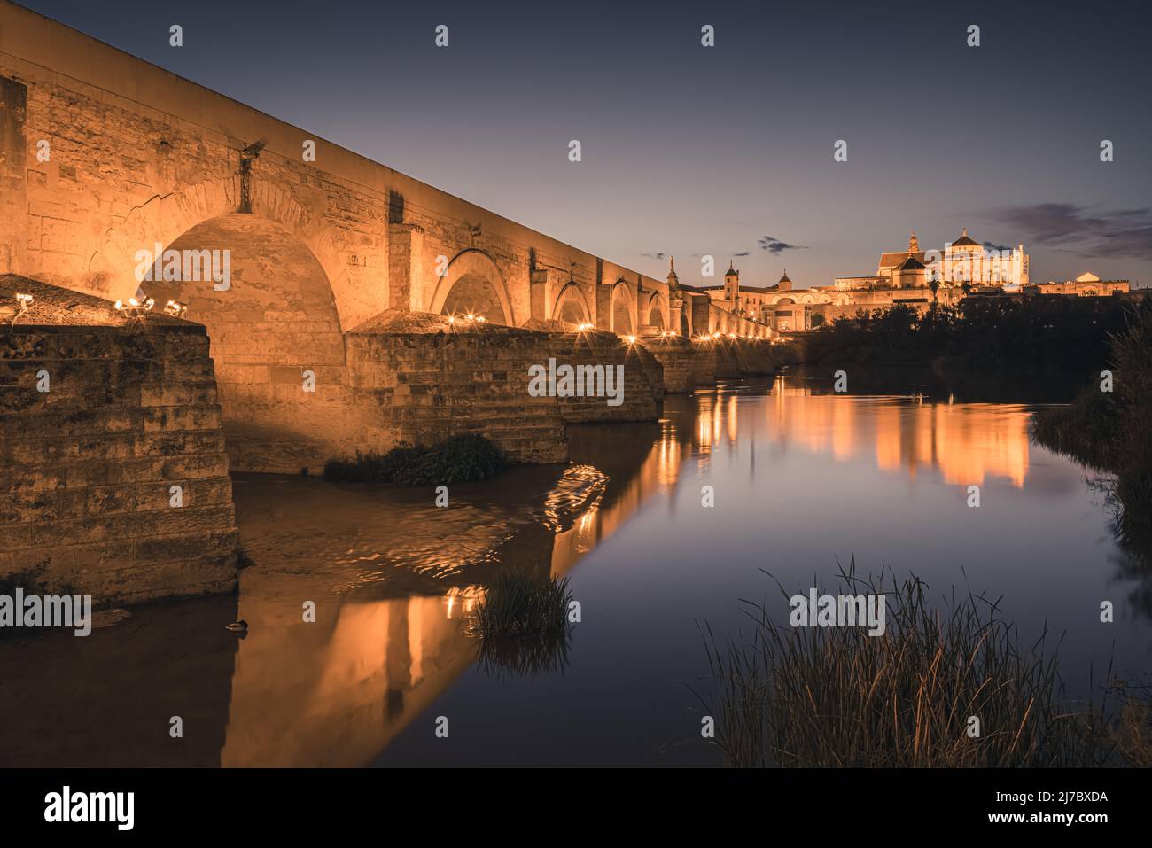 Una noche en el antiguo Puente Romano de Córdoba. Al fondo la Gran Mezquita de Córdoba. Tomada en la ciudad de Córdoba, Andalucía, en t Foto de stock