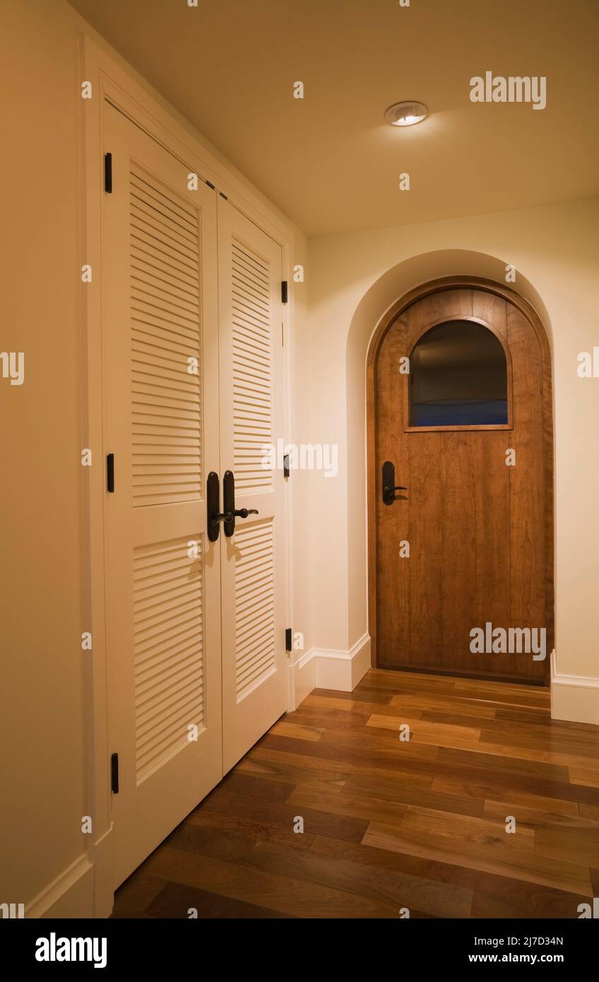 Puerta de madera arqueada con cristal a la bodega en el pasillo dentro de  casa de lujo Fotografía de stock - Alamy