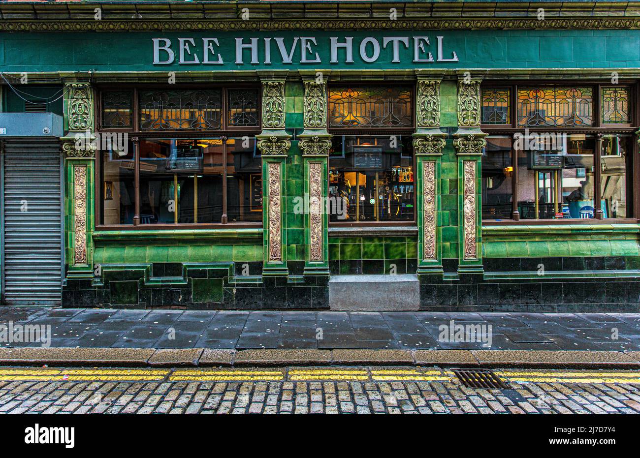 El exterior de la casa pública del Beehive Hotel está frente a azulejos verdes y amarillos. High Bridge , Newcastle upon Tyne, Inglaterra. Foto de stock