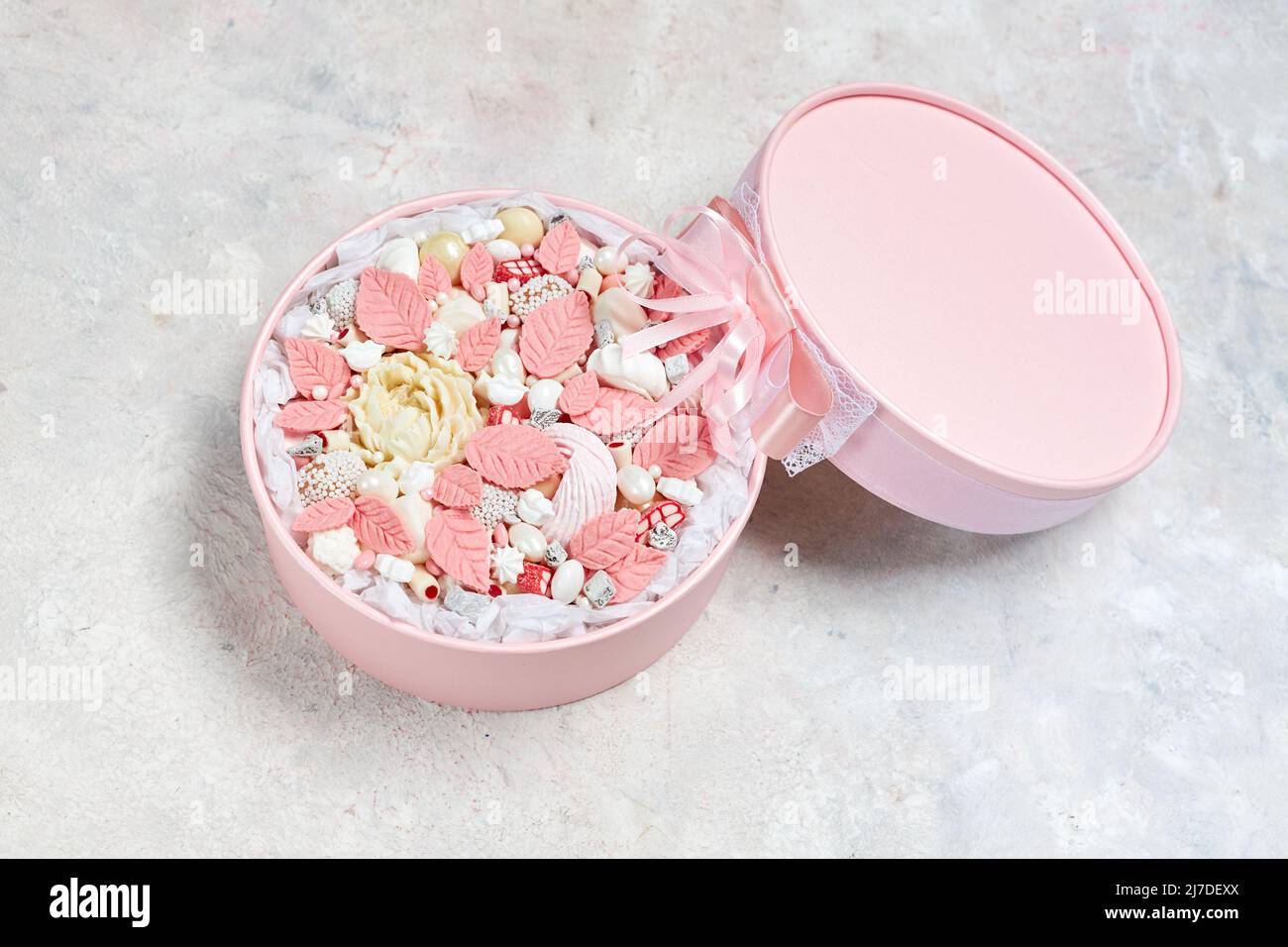 Caja rosa con dulces de chocolate blanco y rosa hechos a mano Foto de stock