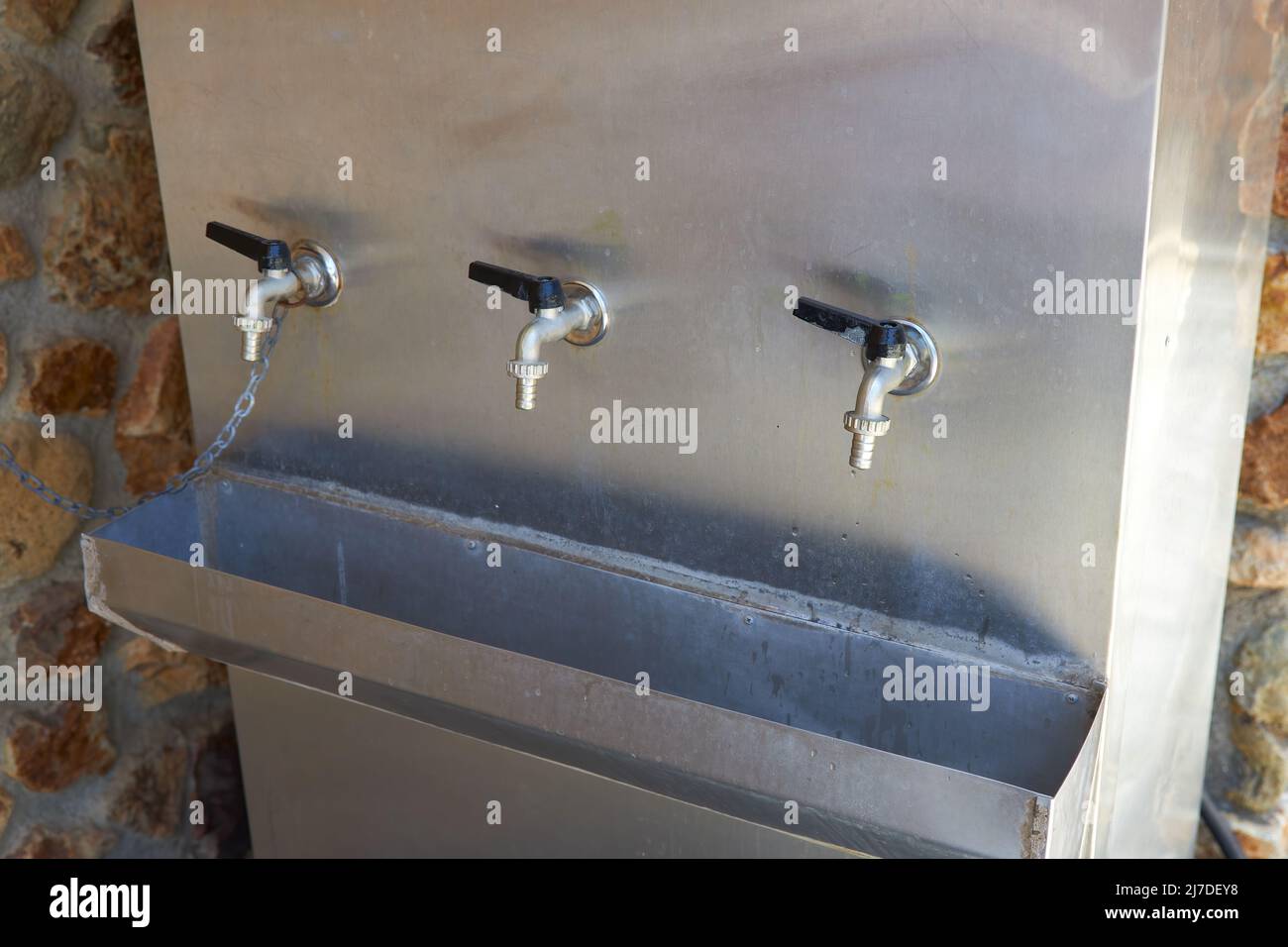 Tanque de metal con agua potable y tres grifos Foto de stock