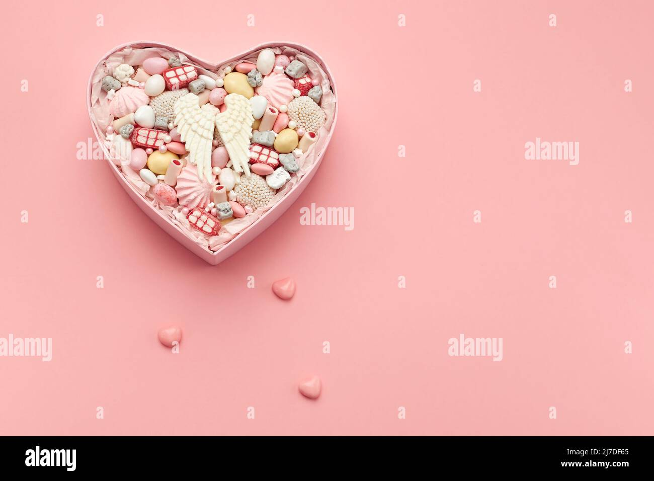 Caja con dulces sobre fondo rosa en blanco para una tarjeta de felicitación Foto de stock