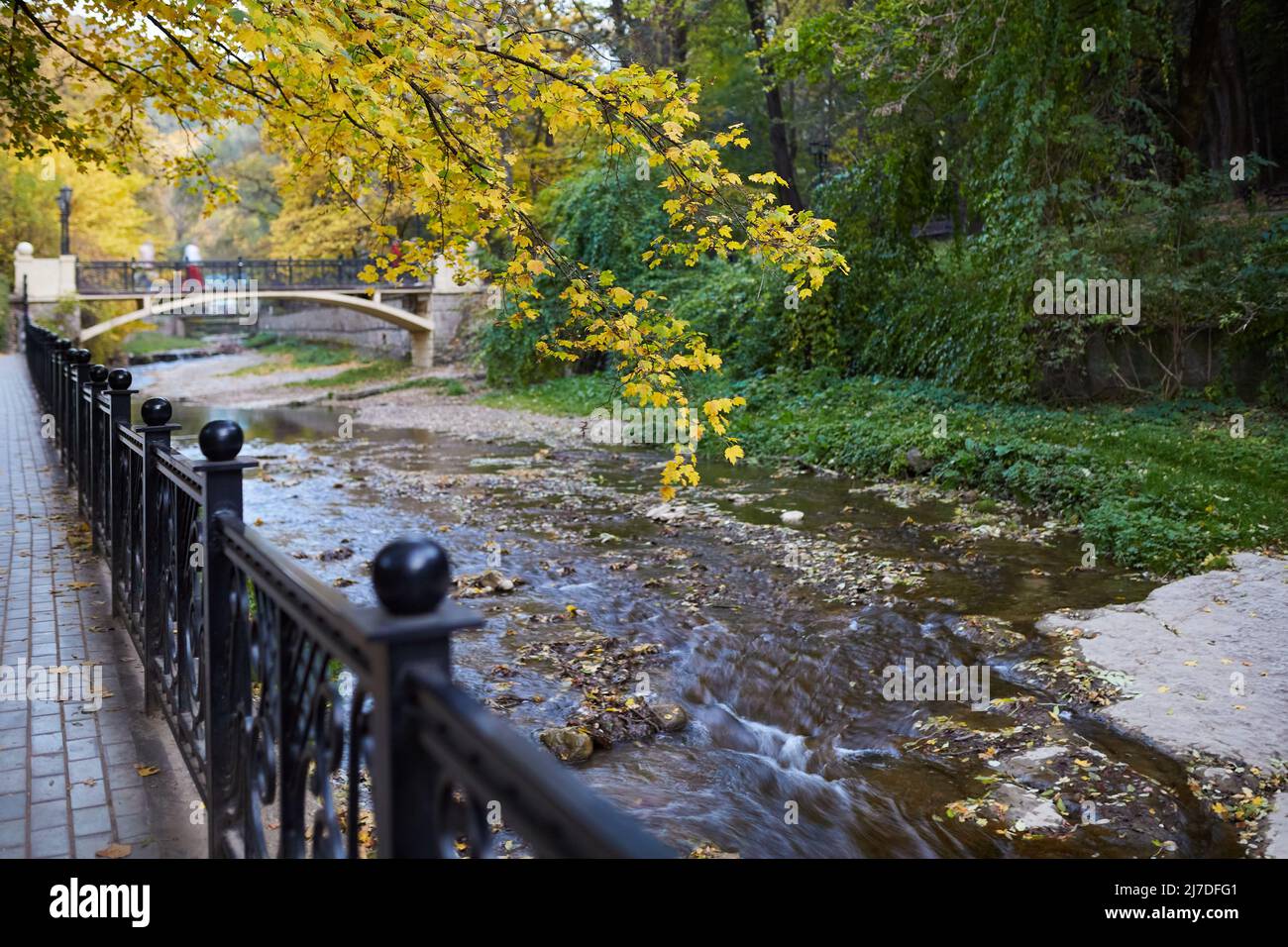 Pequeño río fluye en un hermoso parque otoñal en el centro de la ciudad Foto de stock